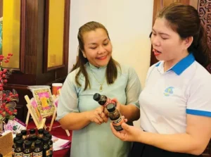 Trần Thị Ngọ (trái) giới thiệu sản phẩm tới khách hàng