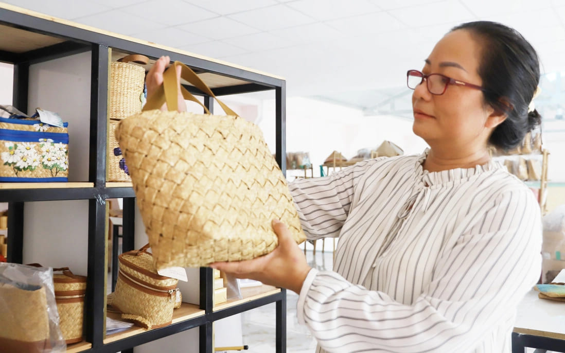 Chị Dư Ngọc Huyền Trang bên sản phẩm được làm từ cây cỏ bàng