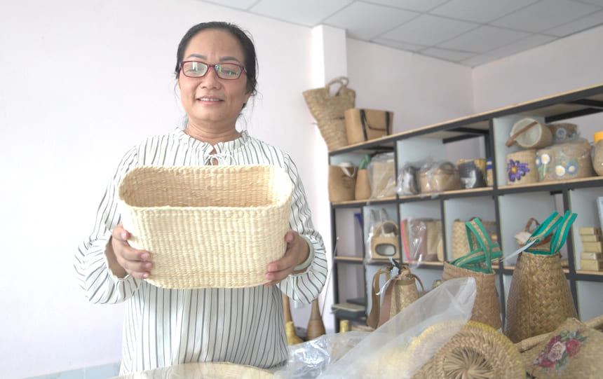 Chị Dư Ngọc Huyền Trang bên sản phẩm túi xách được làm từ lục bình