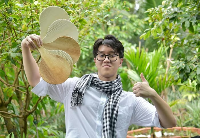 Học sinh Phạm Trần Duy với sản phẩm quạt làm từ mo cau
