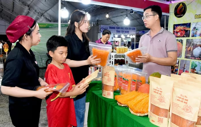 Anh Trần Thanh Phúc giới thiệu sản phẩm từ gấc cho khách tham quan tại Hội chợ Xúc tiến thương mại, sản phẩm OCOP - Rạch Giá, An Giang năm 2025