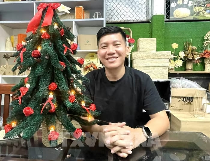 Anh Đỗ Đăng Khoa, chủ dự án “Làng mướp” cùng với cây thông Noel trang trí bằng cơ mướp